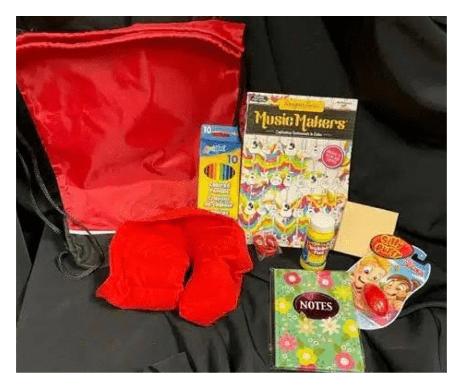School Age Kids Bag and some items it includes: journal, pencils, coloring book, silly putty and blanket